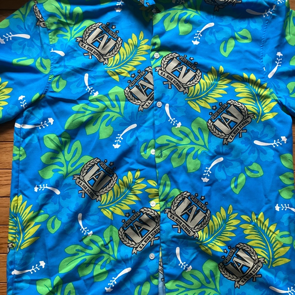 Vibrant Blue Hawaiian Shirt with Leaf and Crest Design